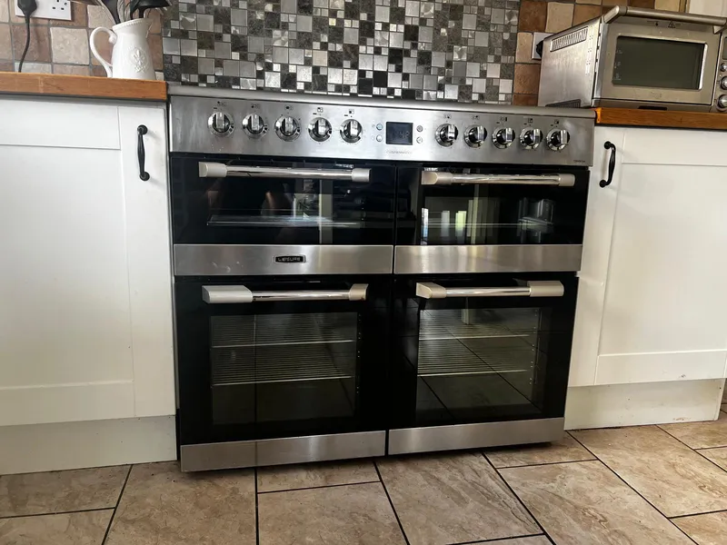 Range cooker with two ovens cleaned, in a kitchen with a tiled splashback